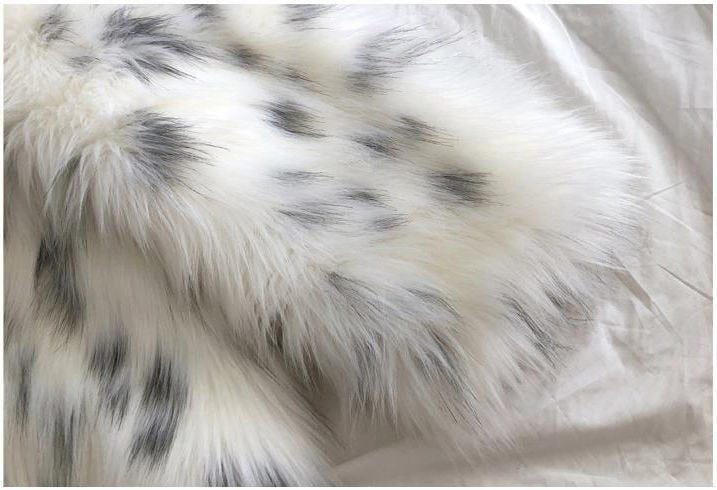 Women wearing a stylish snow leopard print faux fox fur coat, showcasing its luxurious texture and elegant design.