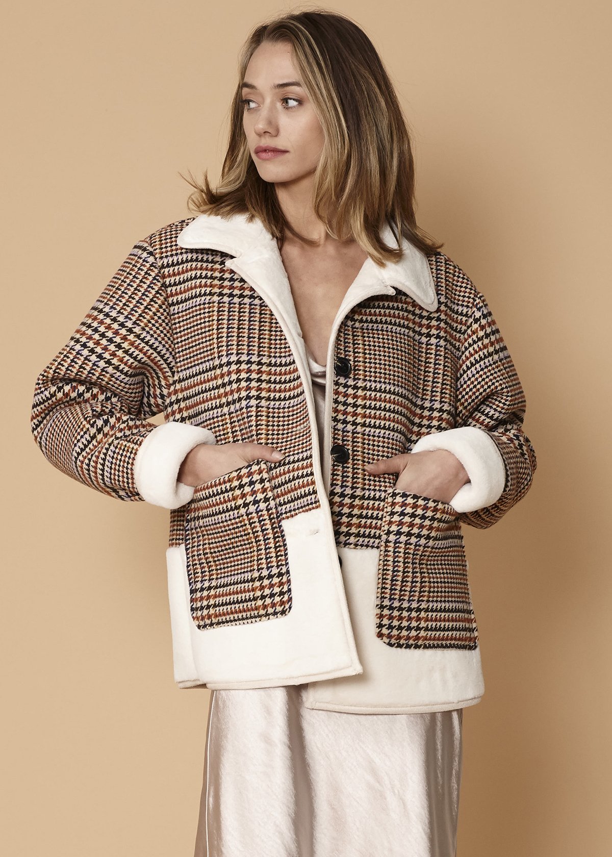 Women's plaid fur jacket in rust houndstooth with two front pockets, showcasing a stylish and cozy design.