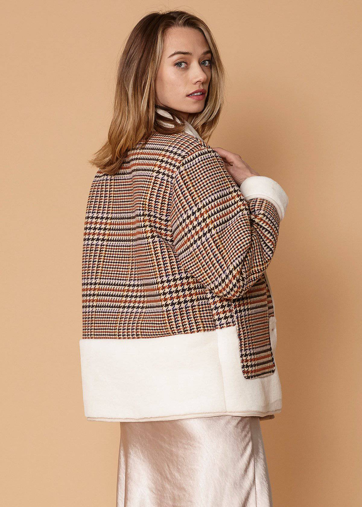 Women's plaid fur jacket in rust houndstooth with two front pockets, showcasing a stylish and cozy design.