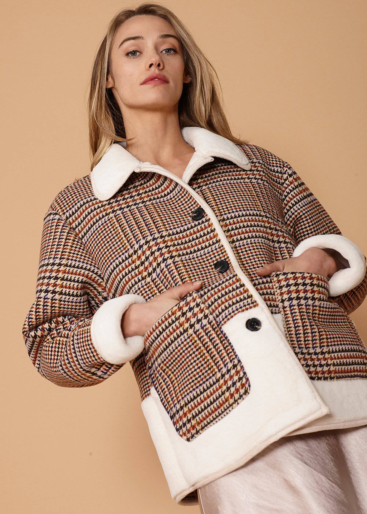 Women's plaid fur jacket in rust houndstooth with two front pockets, showcasing a stylish and cozy design.