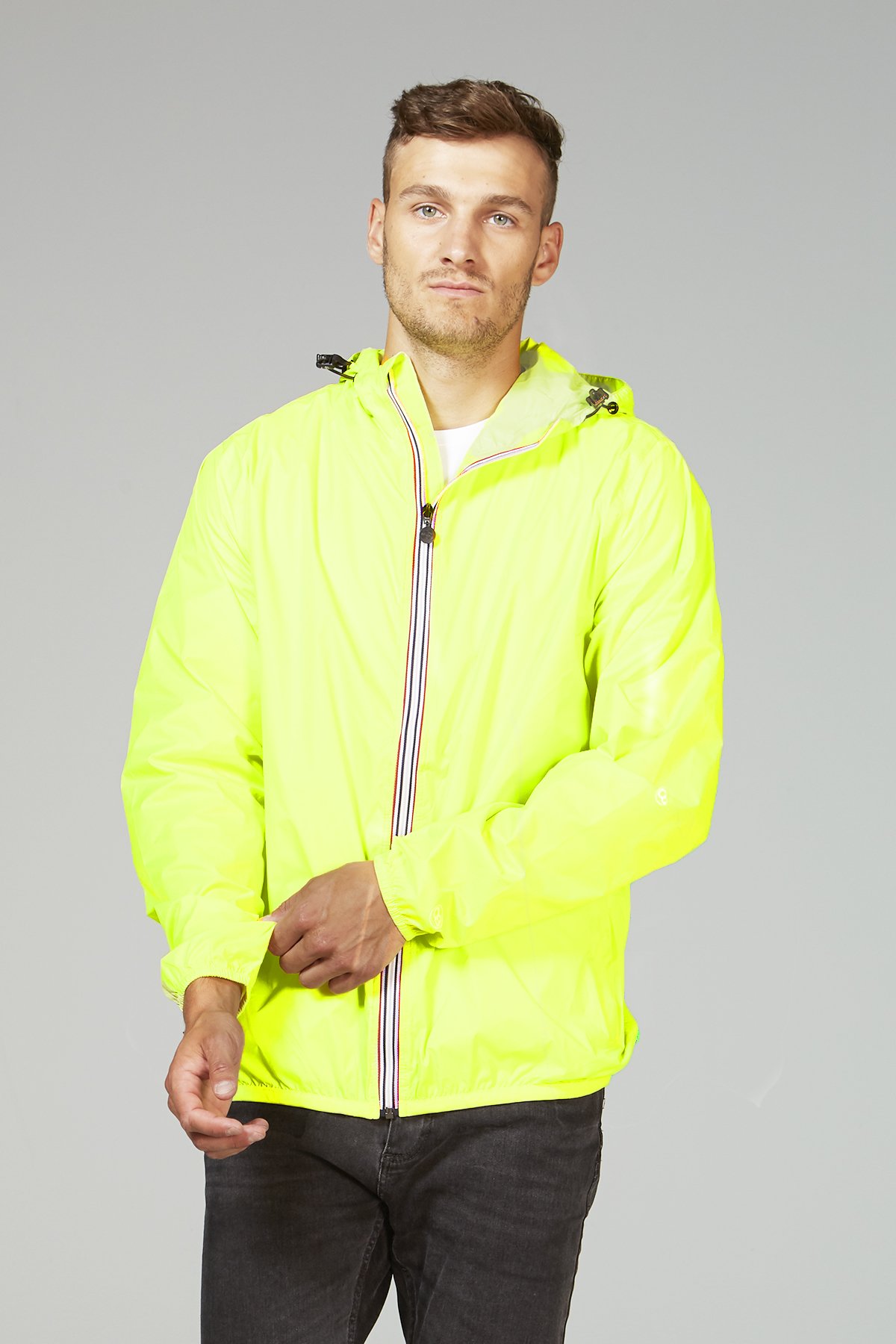 A vibrant yellow fluo full zip packable rain jacket, showcasing its waterproof material and compact design, perfect for outdoor activities.