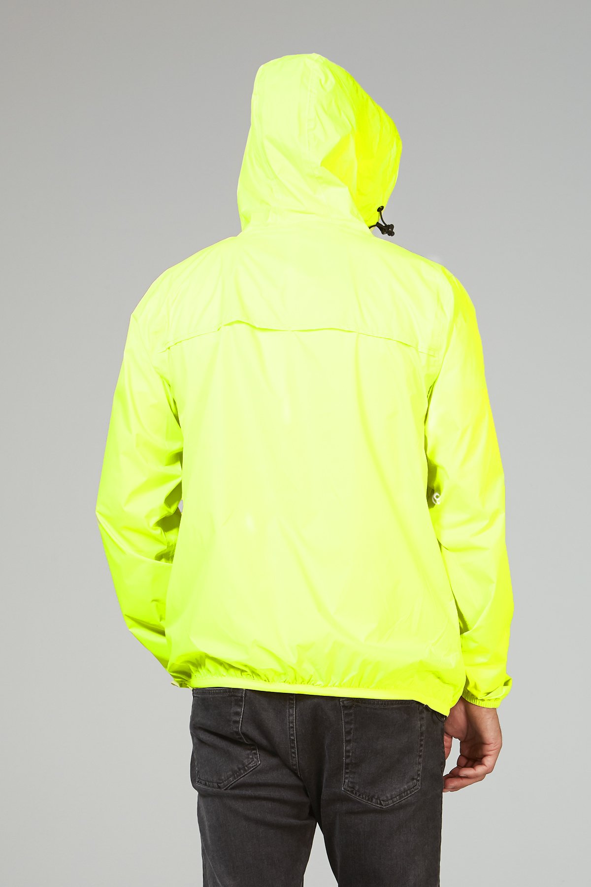 A vibrant yellow fluo full zip packable rain jacket, showcasing its waterproof material and compact design, perfect for outdoor activities.