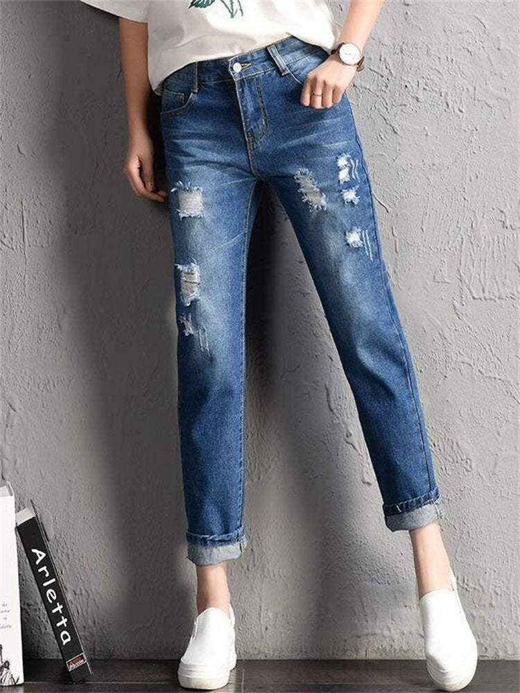 A pair of stylish mid-waist boyfriend jeans featuring big ripped holes, made from a soft cotton-polyester blend, perfect for casual wear.