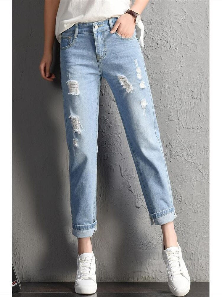 A pair of stylish mid-waist boyfriend jeans featuring big ripped holes, made from a soft cotton-polyester blend, perfect for casual wear.