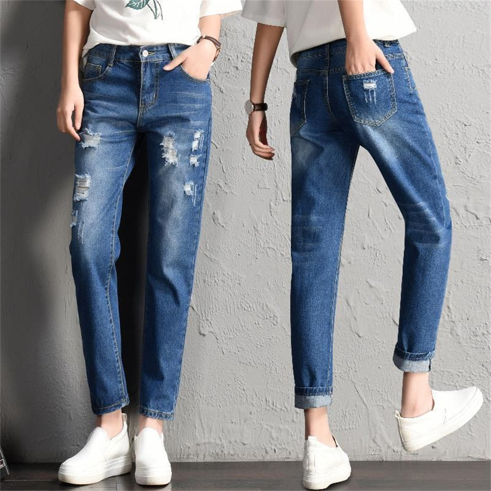 A pair of stylish mid-waist boyfriend jeans featuring big ripped holes, made from a soft cotton-polyester blend, perfect for casual wear.