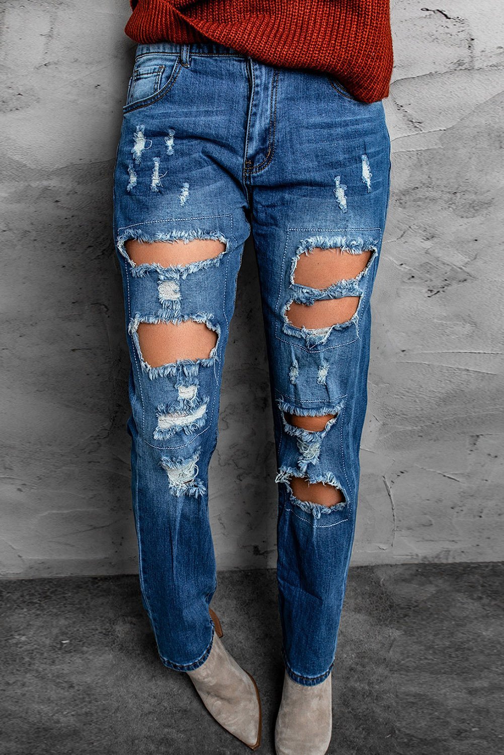 A pair of blue distressed ripped jeans showcasing stylish rips and a casual fit, perfect for various occasions.