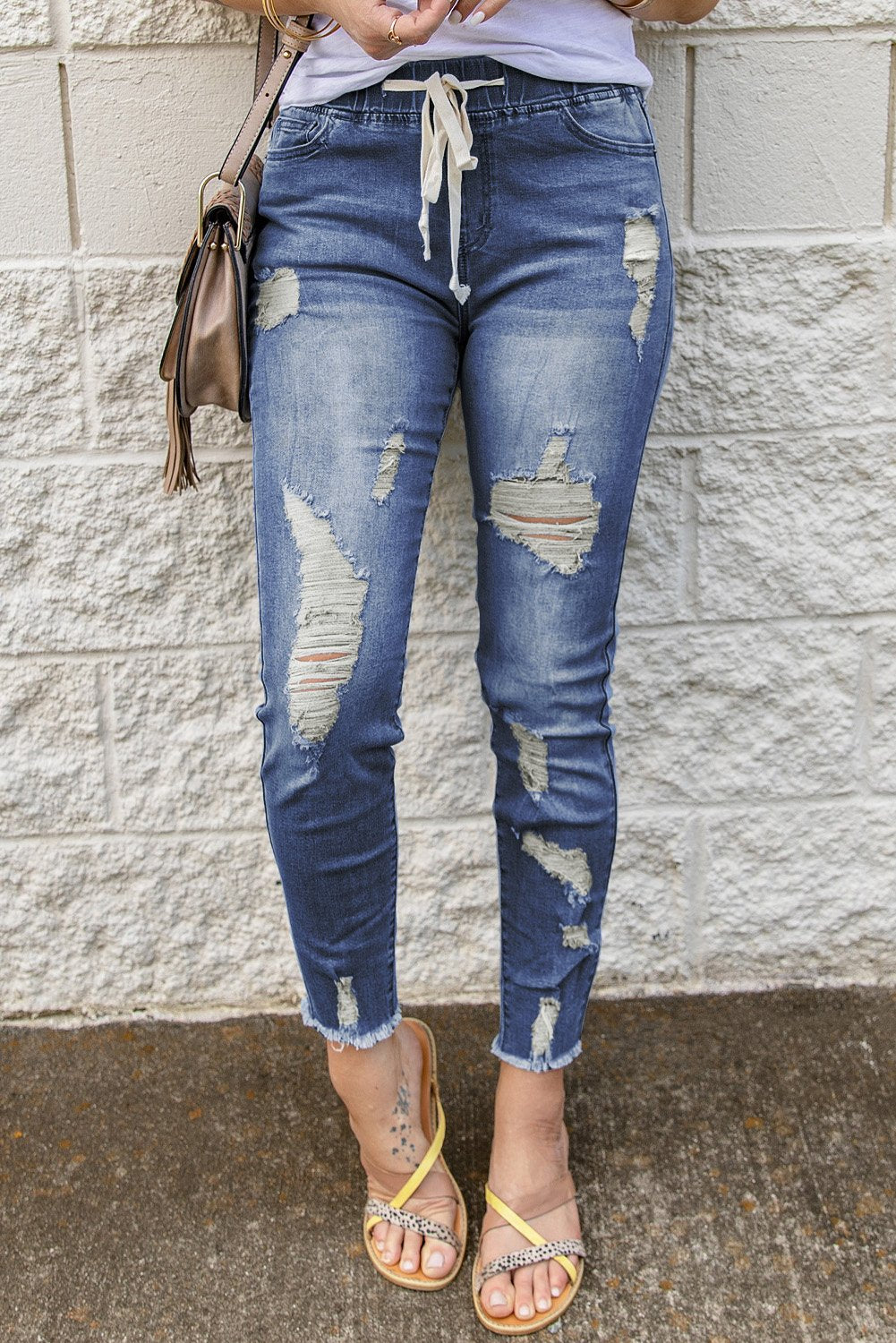 A pair of stylish blue hole ripped jeans featuring a drawstring elastic waist, slim fit, and raw cropped anklets, perfect for summer casual wear.