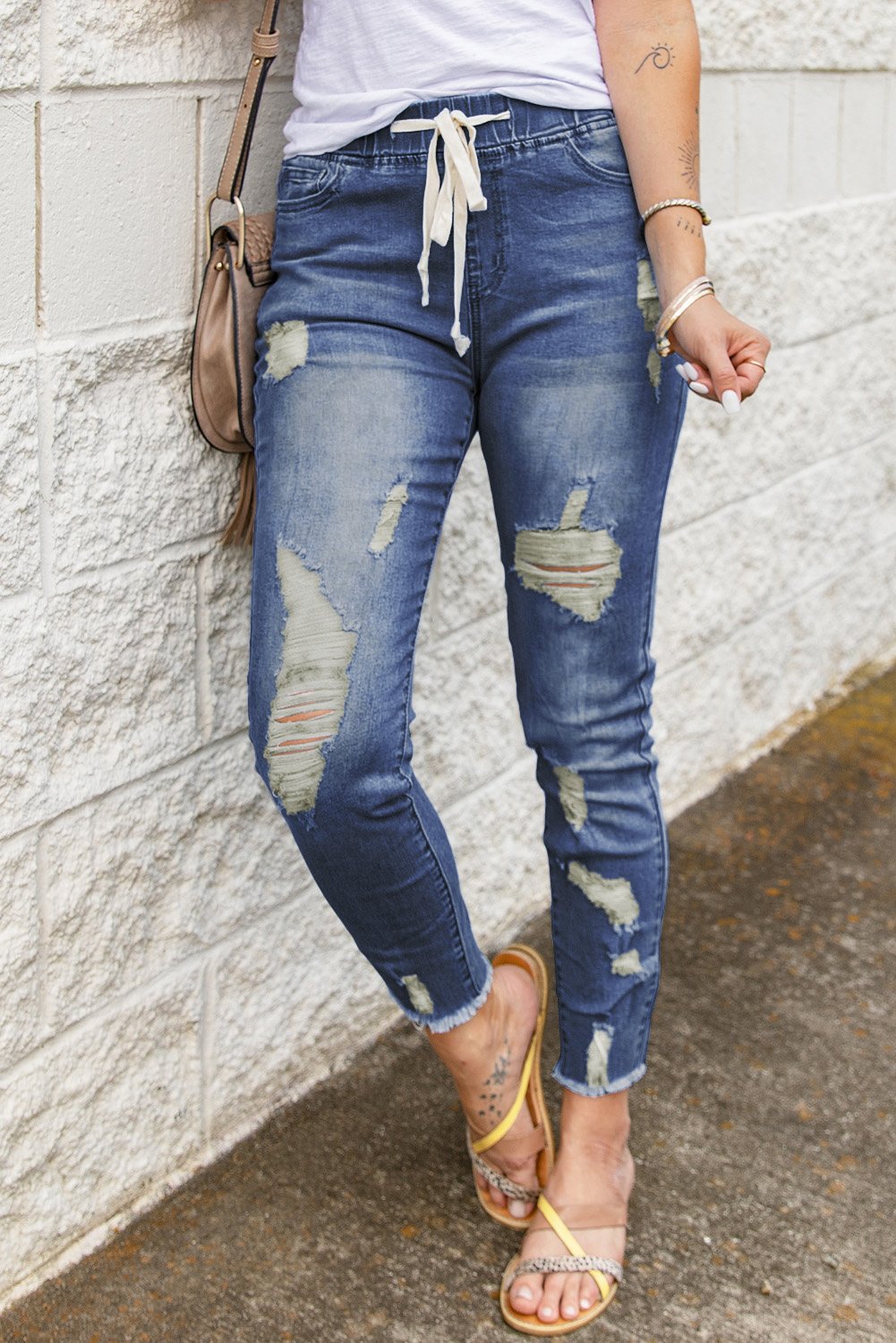 A pair of stylish blue hole ripped jeans featuring a drawstring elastic waist, slim fit, and raw cropped anklets, perfect for summer casual wear.