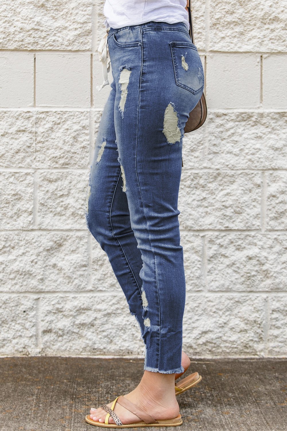 A pair of stylish blue hole ripped jeans featuring a drawstring elastic waist, slim fit, and raw cropped anklets, perfect for summer casual wear.