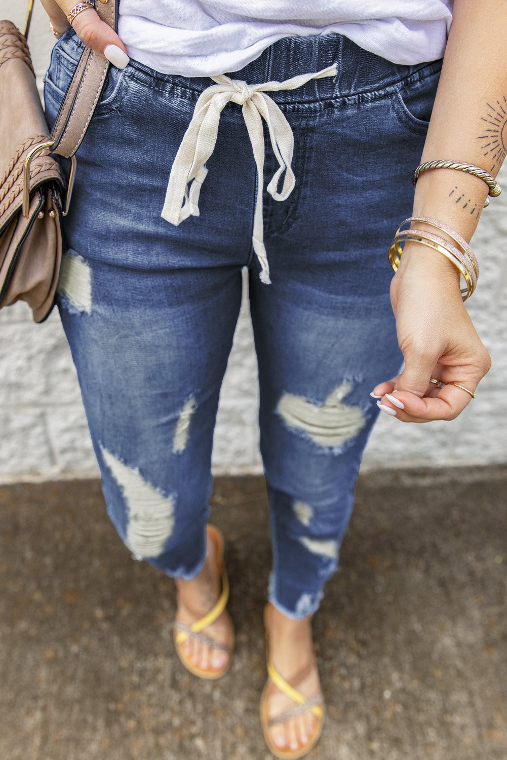 A pair of stylish blue hole ripped jeans featuring a drawstring elastic waist, slim fit, and raw cropped anklets, perfect for summer casual wear.