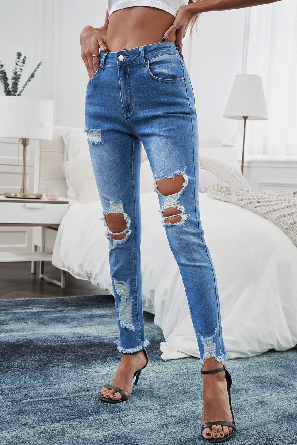 A pair of light blue distressed skinny jeans featuring a high waist, stylish holes, and pockets, perfect for casual wear.