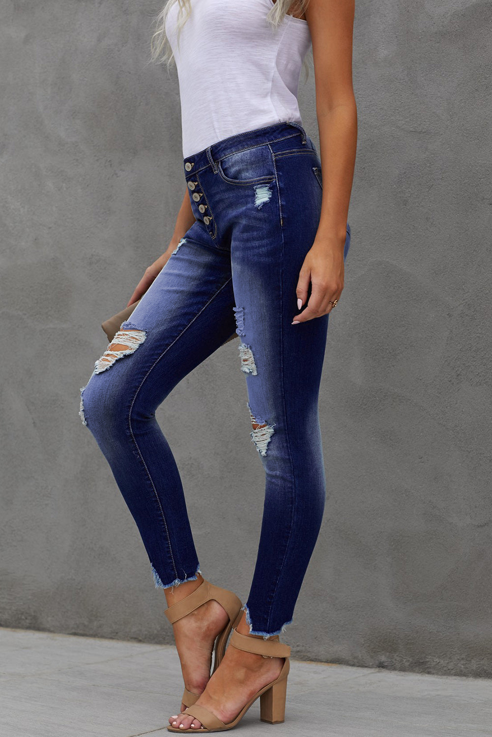 High Rise Button Front Frayed Ankle Skinny Jeans in medium wash with distressed details and raw edges, showcasing front button closures and five pockets.