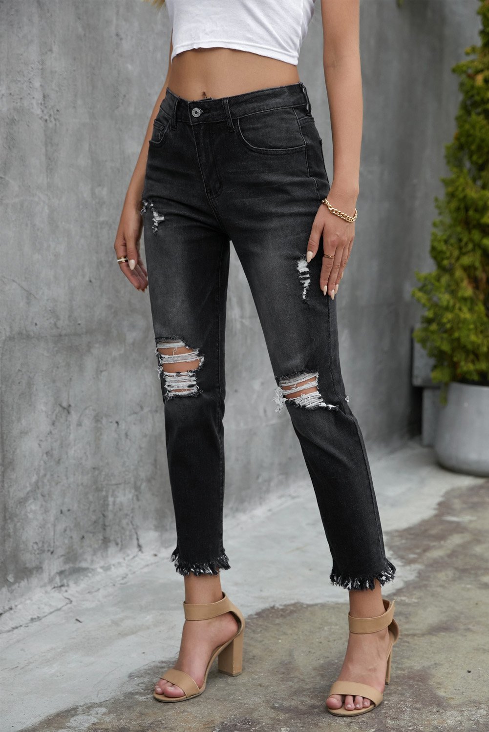 A pair of stylish black mid waist jeans featuring a straight leg design, light distressing, and functional pockets, perfect for casual wear.