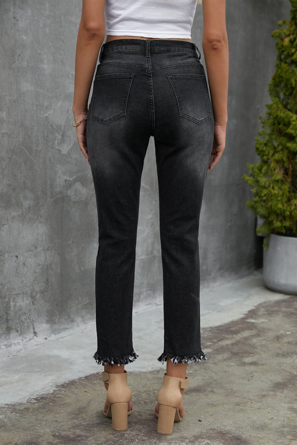 A pair of stylish black mid waist jeans featuring a straight leg design, light distressing, and functional pockets, perfect for casual wear.