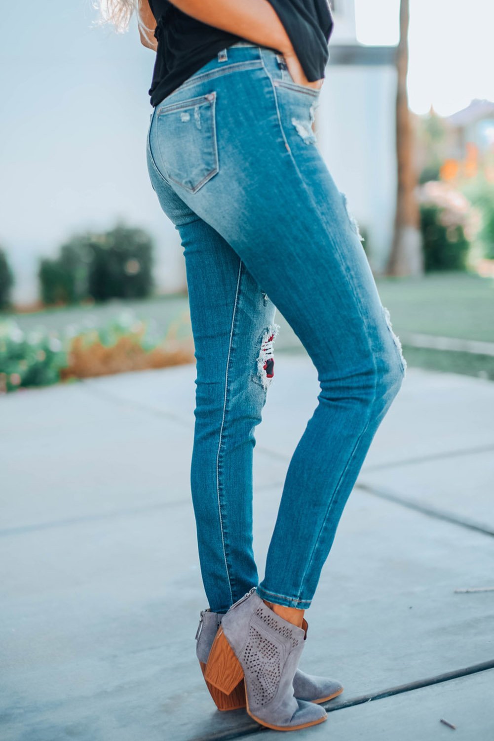 A pair of Women's Fashion Red Plaid Patch Destroyed Skinny Jeans featuring distressed details, plaid patches on the front legs, and a skinny fit silhouette.