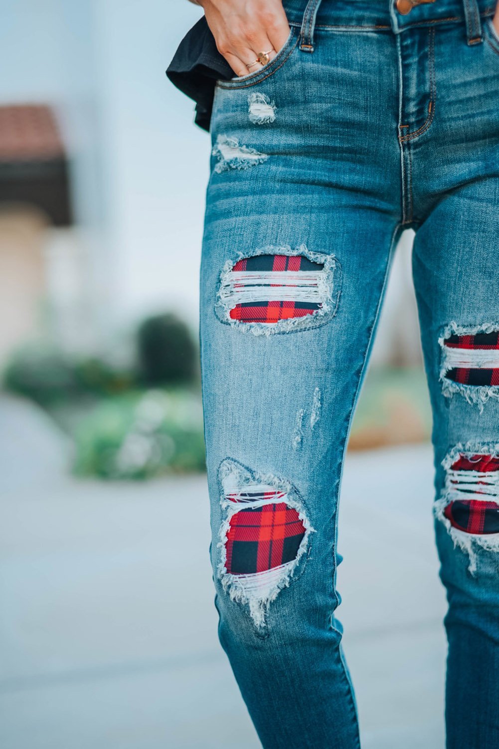 A pair of Women's Fashion Red Plaid Patch Destroyed Skinny Jeans featuring distressed details, plaid patches on the front legs, and a skinny fit silhouette.