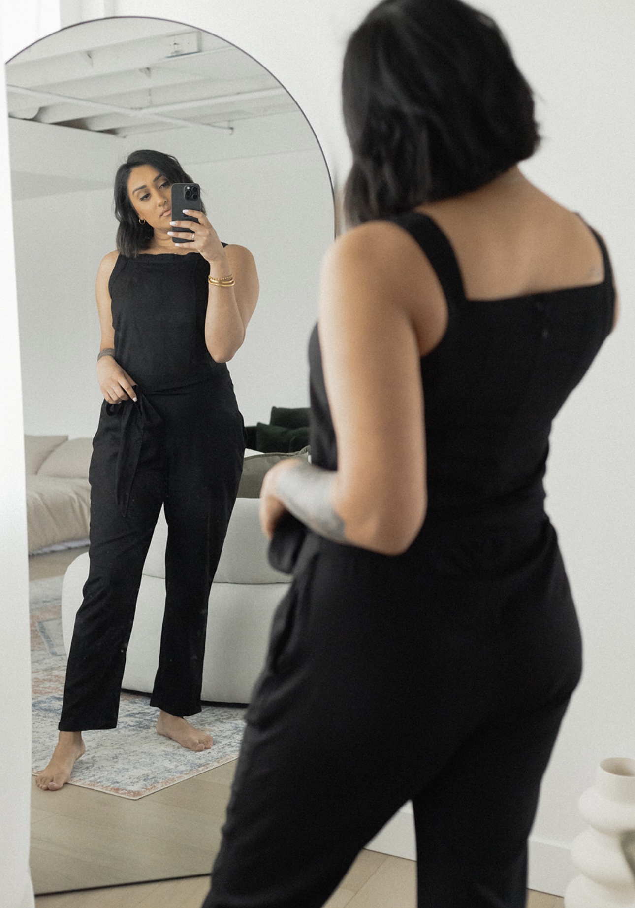 A stylish black jumpsuit featuring a square neck, adjustable waistband, and tapered legs, perfect for various occasions.