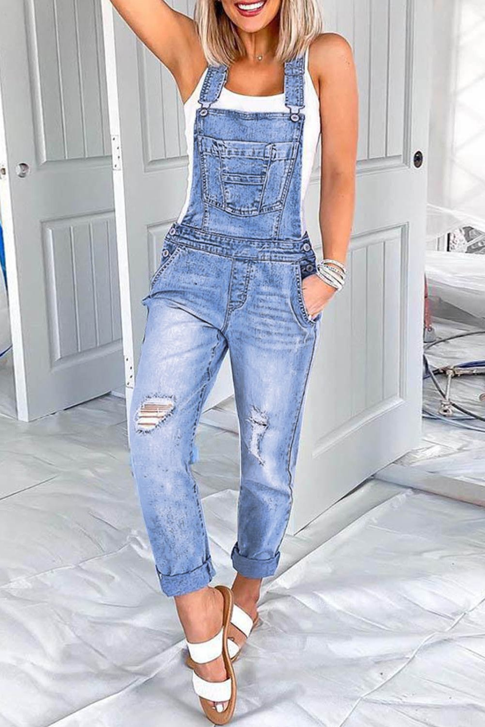 Fashion One-piece Denim Jumpsuit in light blue with adjustable straps, multiple pockets, and distressed details, perfect for casual wear.