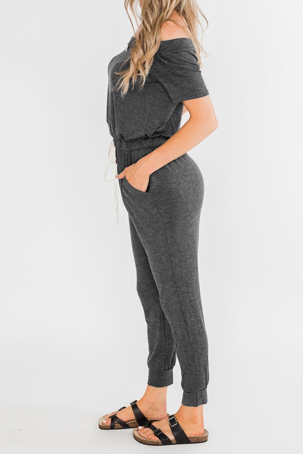 Gray off-the-shoulder drawstring jogger jumpsuit featuring short sleeves and pockets, perfect for summer casual wear.