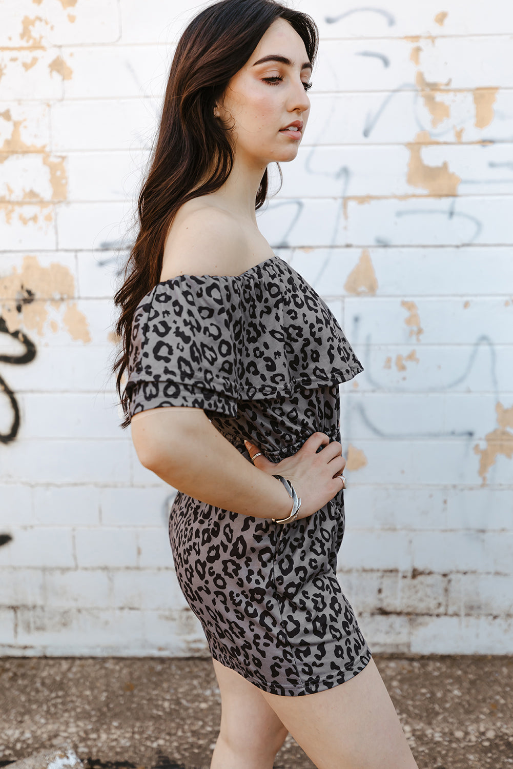 A stylish leopard print off-shoulder romper with pockets, displayed in a flat lay outdoors, showcasing its casual and chic design.