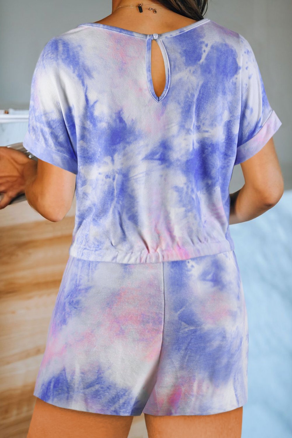 Multicolor Pocketed Tie Dye Short Sleeve Knit Romper featuring a vibrant tie-dye pattern, short sleeves, and an elastic drawstring waist for a comfortable fit.