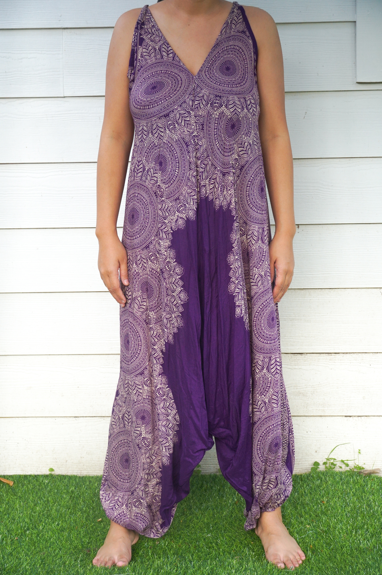 A vibrant Purple Lotus Hippie Jumpsuit featuring a boho design, wide legs, and adjustable straps, perfect for summer festivals.