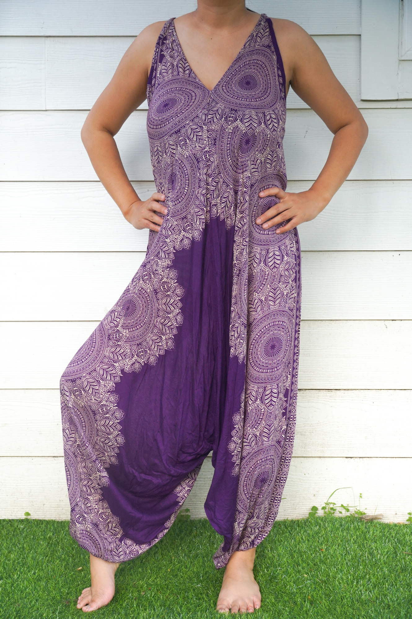 A vibrant Purple Lotus Hippie Jumpsuit featuring a boho design, wide legs, and adjustable straps, perfect for summer festivals.