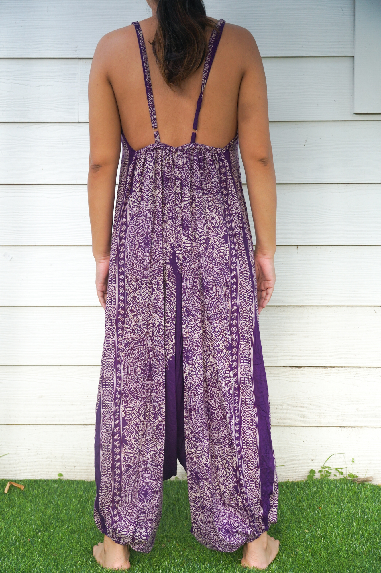 A vibrant Purple Lotus Hippie Jumpsuit featuring a boho design, wide legs, and adjustable straps, perfect for summer festivals.