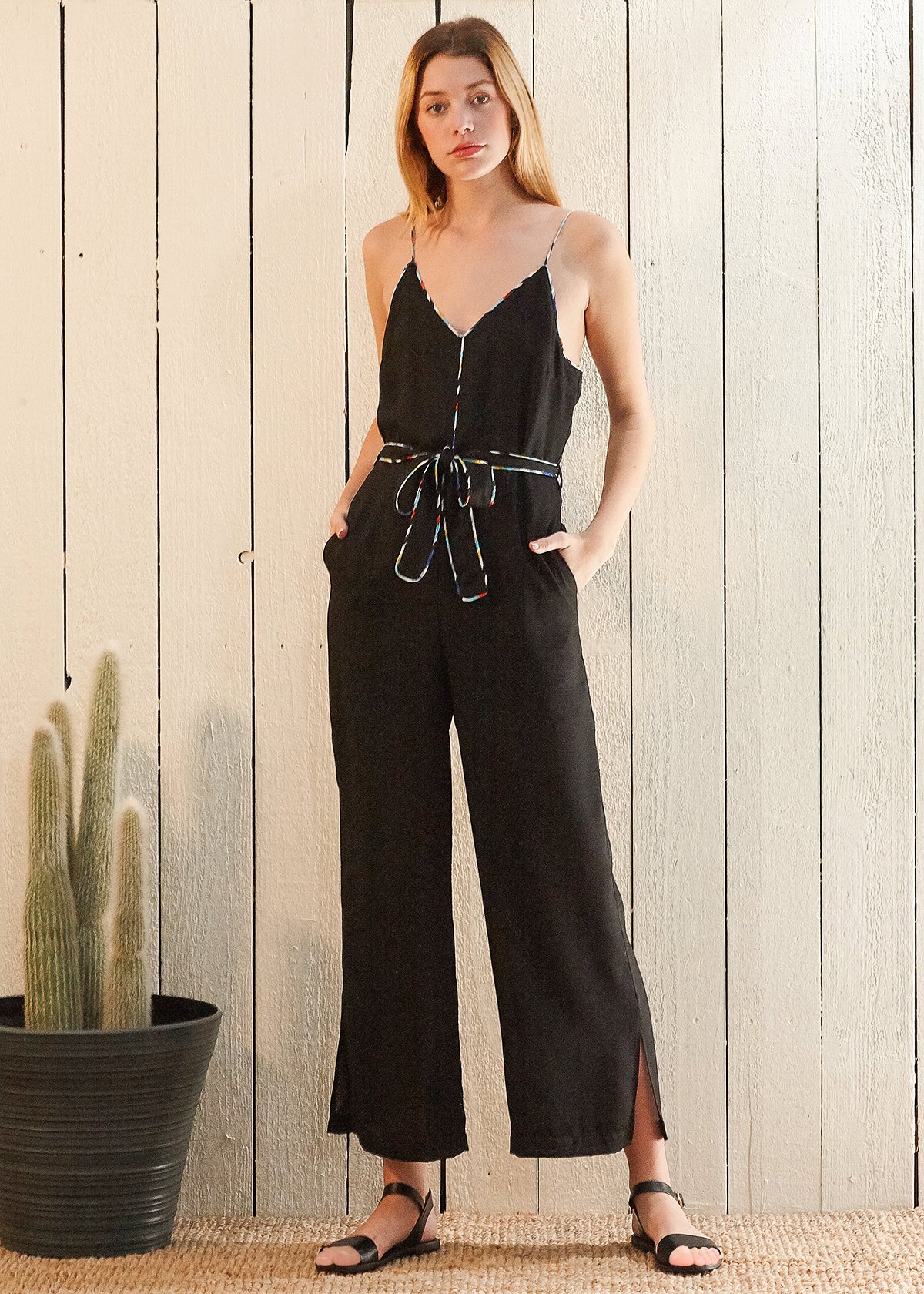 Women's black jumpsuit featuring multi-color binding, self-tie belt, and side pockets, perfect for various occasions.