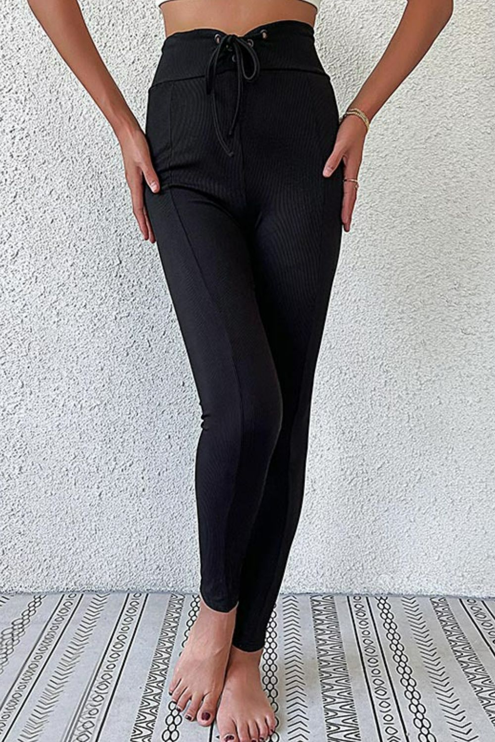 A pair of stylish lace-up skinny pants in solid color, showcasing the trendy design and comfortable fit.