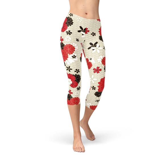 A pair of women's capri leggings featuring a vibrant Japanese cherry blossom print, designed for comfort and performance during workouts.