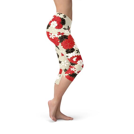 A pair of women's capri leggings featuring a vibrant Japanese cherry blossom print, designed for comfort and performance during workouts.