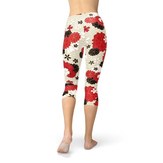 A pair of women's capri leggings featuring a vibrant Japanese cherry blossom print, designed for comfort and performance during workouts.