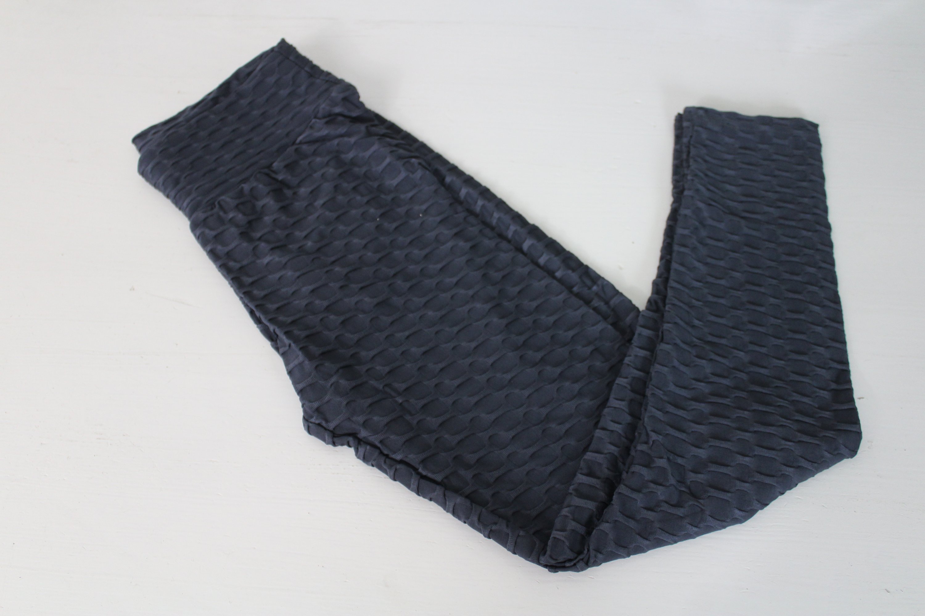 A pair of Women's Bubble Leggings in Black, showcasing the crumple butt design and stretchable fabric, ideal for yoga and fitness activities.