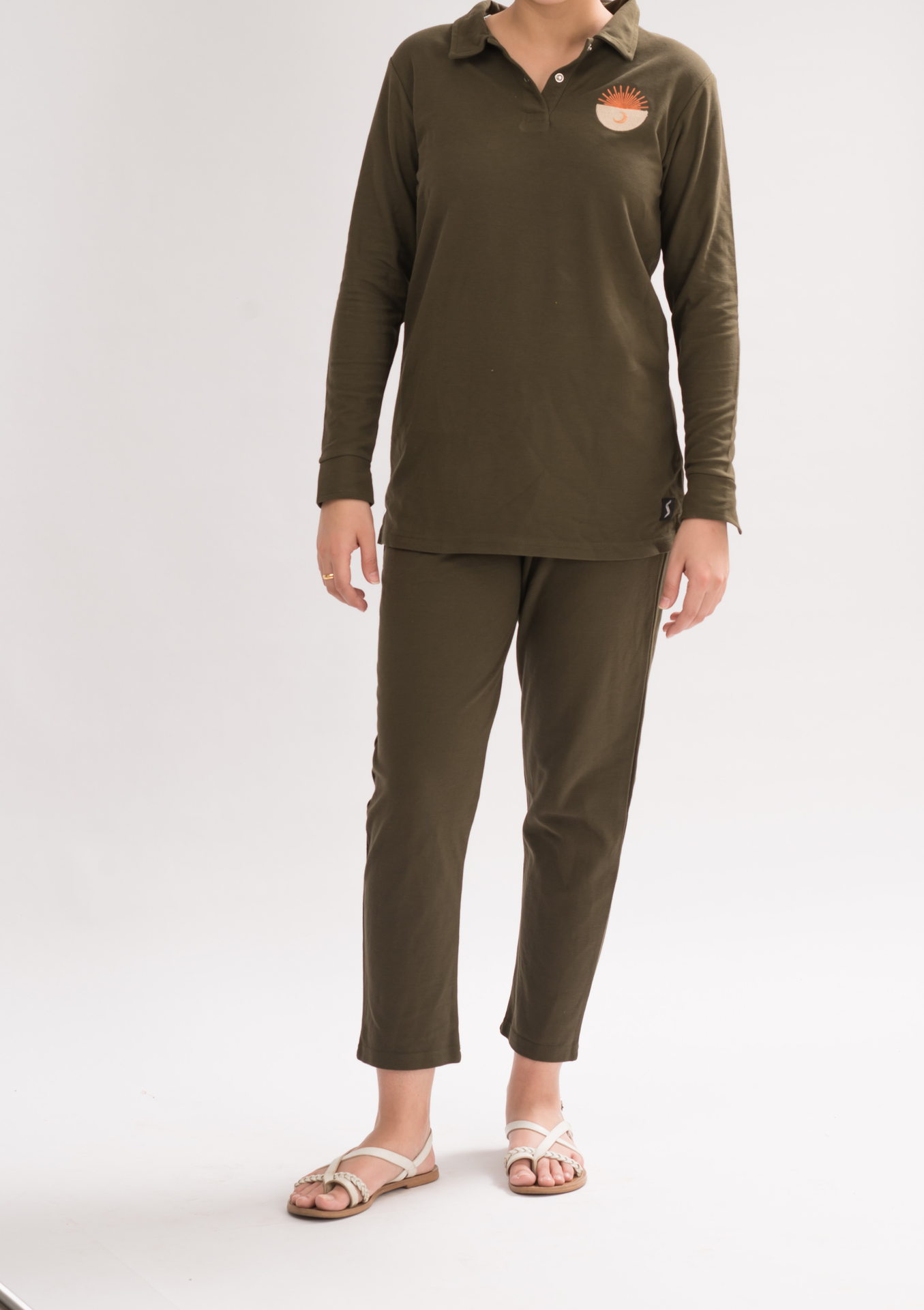 A pair of women's straight fit trousers made from a honeycomb pique cotton blend, featuring an elasticated waistband and a sleek silhouette.