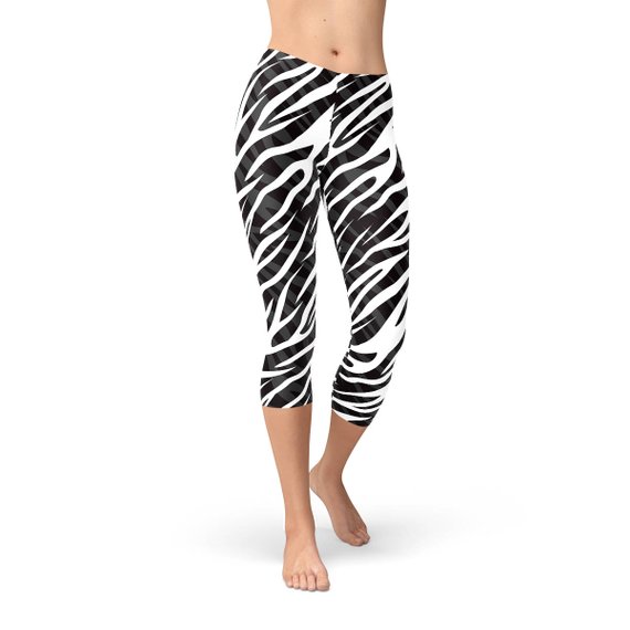 A pair of stylish Womens Zebra Stripes Capri Leggings featuring a bold black and white zebra print design, perfect for workouts and casual wear.