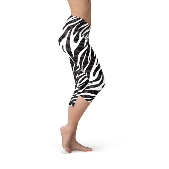 A pair of stylish Womens Zebra Stripes Capri Leggings featuring a bold black and white zebra print design, perfect for workouts and casual wear.