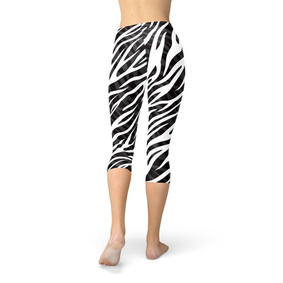 A pair of stylish Womens Zebra Stripes Capri Leggings featuring a bold black and white zebra print design, perfect for workouts and casual wear.