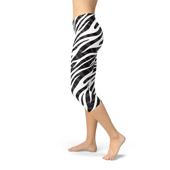 A pair of stylish Womens Zebra Stripes Capri Leggings featuring a bold black and white zebra print design, perfect for workouts and casual wear.