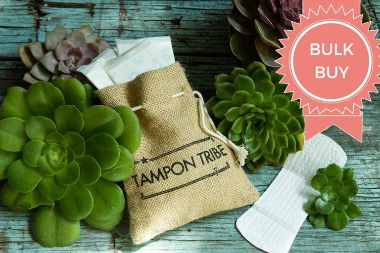 A collection of organic cotton pads in a stylish jute bag, showcasing eco-friendly packaging and a variety of day and night pads.