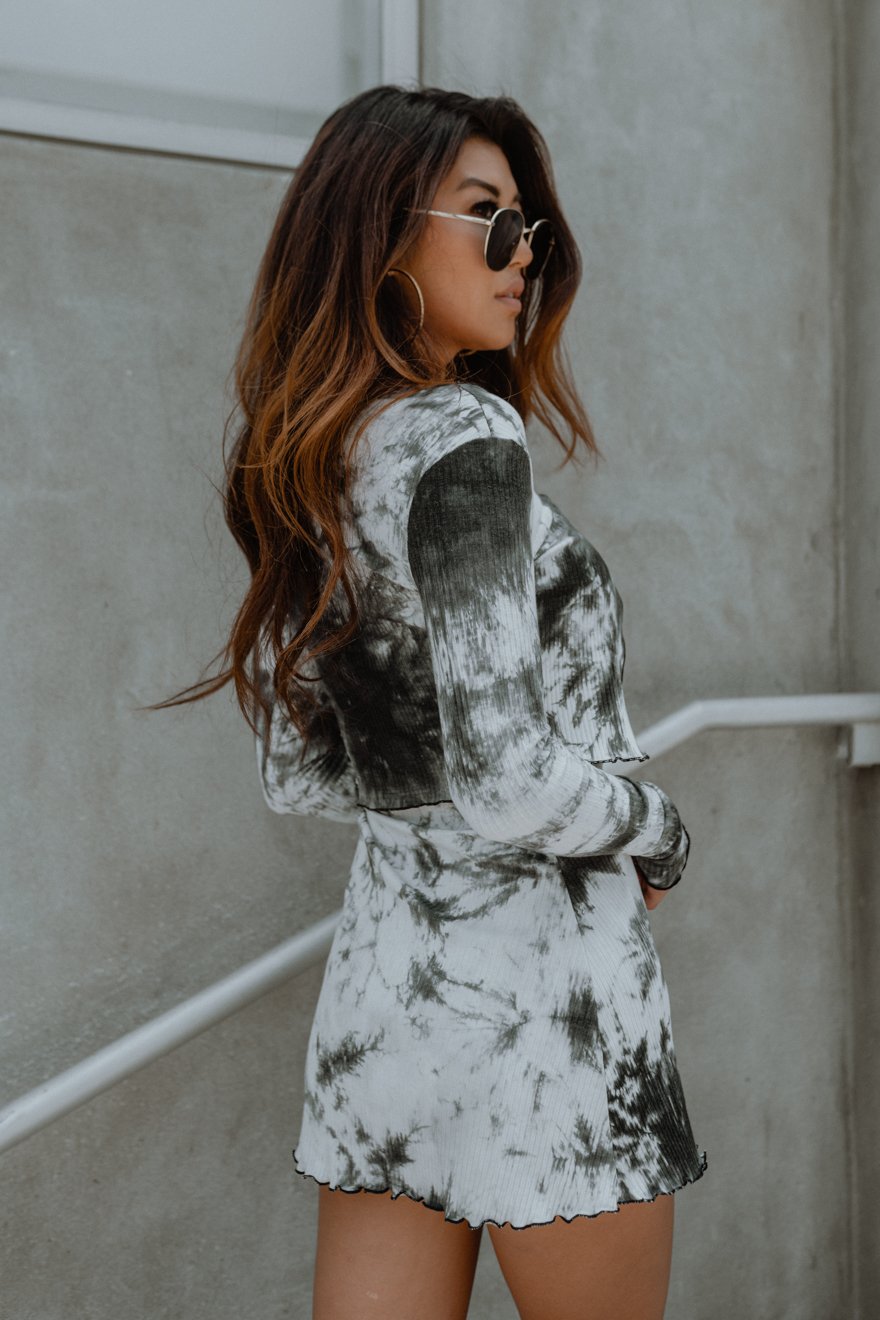 A stylish Picnic in the Park Dress and Cardigan Set featuring a strapless tie-dye dress with a lettuce hem and a matching front-tie cardigan.