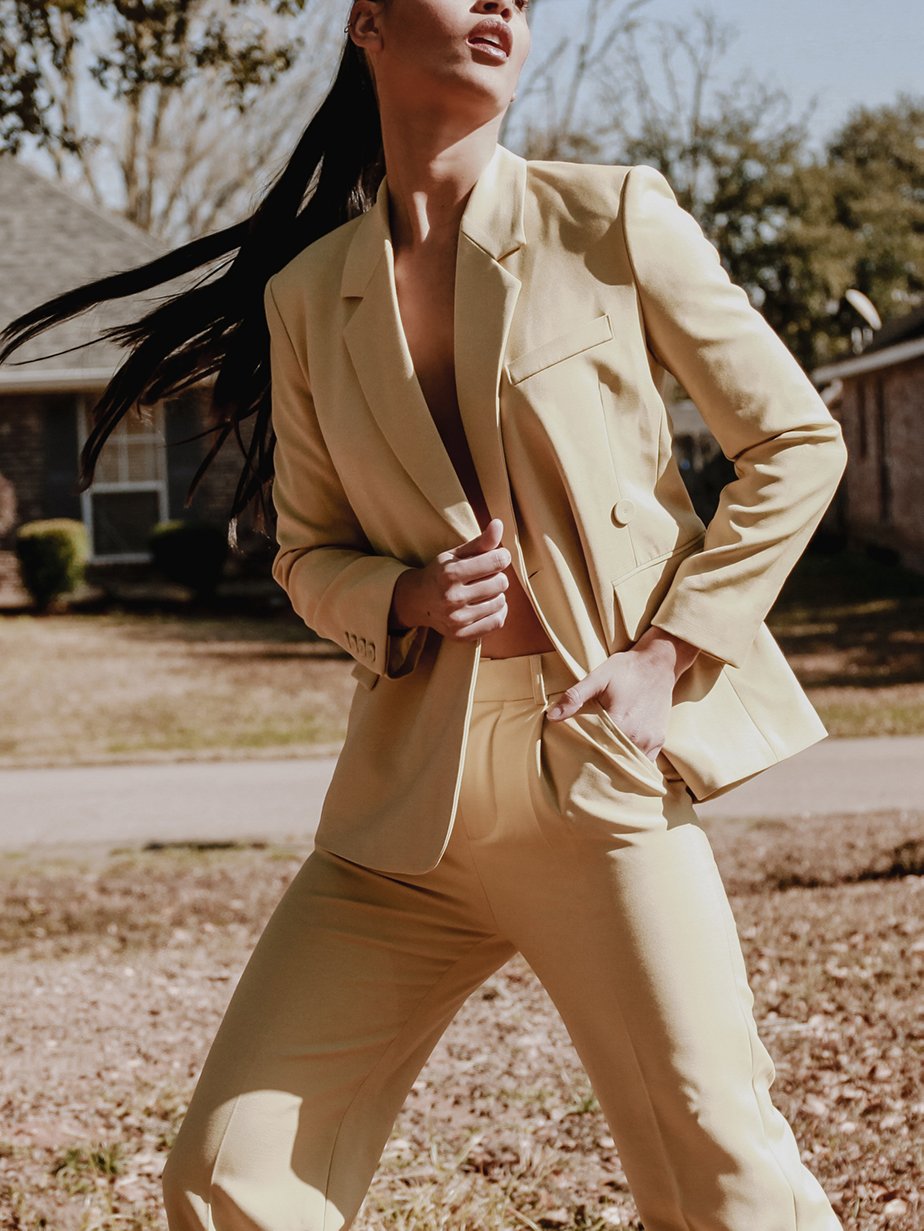 A stylish yellow blazer with an asymmetrical notched collar, single-button front, and welted pockets, designed for confident women.