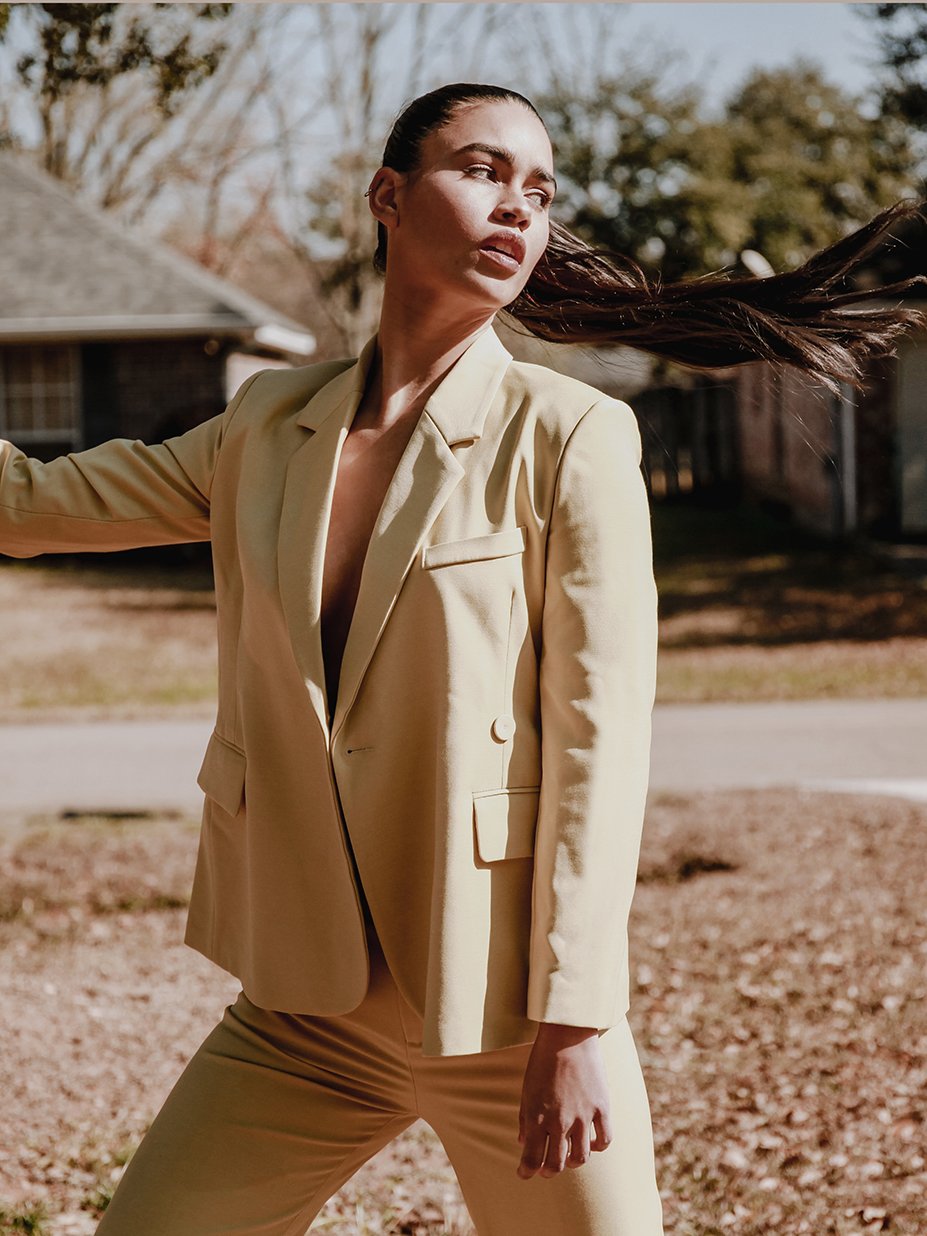 A stylish yellow blazer with an asymmetrical notched collar, single-button front, and welted pockets, designed for confident women.