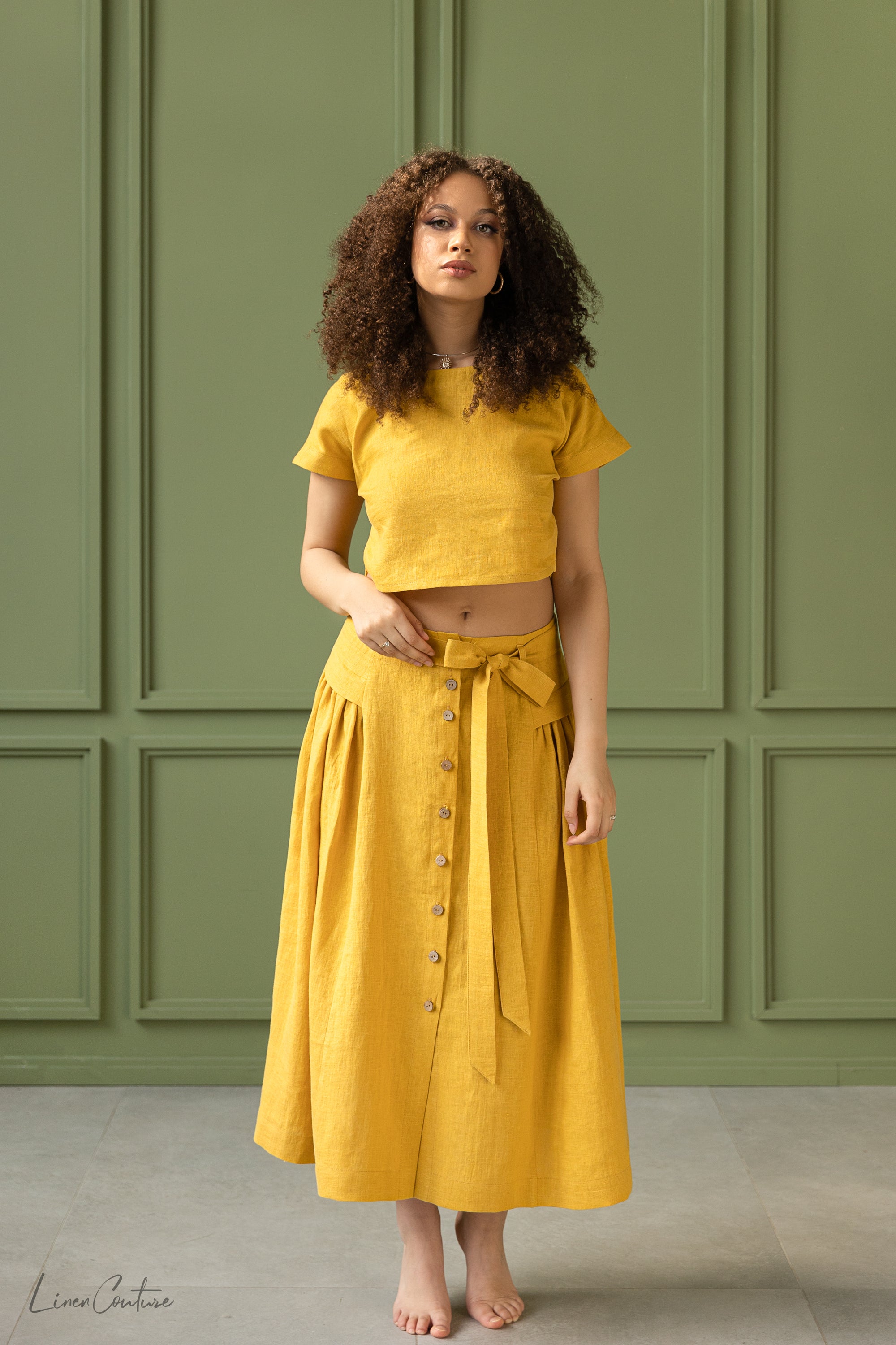 Taormina Honey Linen Crop Top and Midi Skirt Set displayed on a model, showcasing its elegant design and earthy beige color.