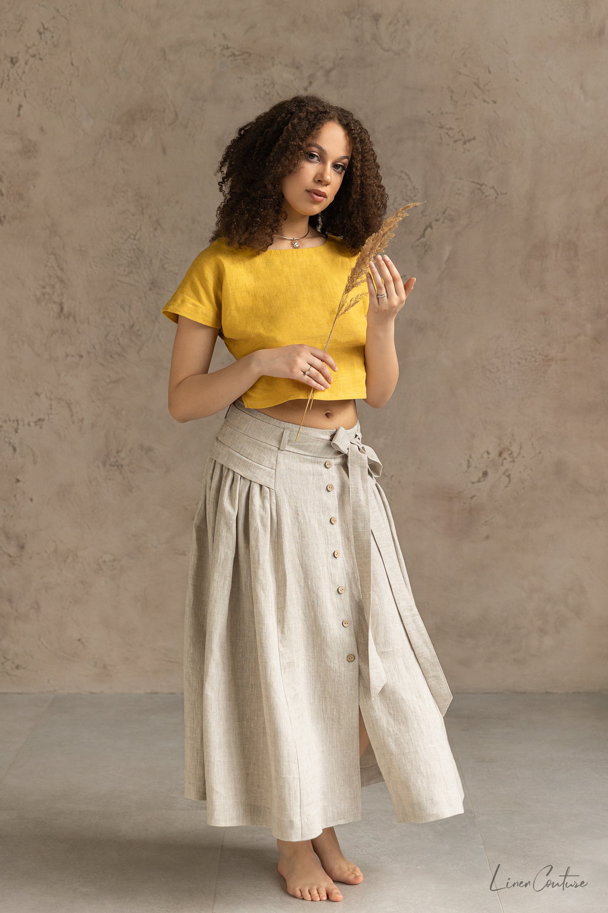 Taormina Honey Linen Crop Top and Midi Skirt Set displayed on a model, showcasing its elegant design and earthy beige color.