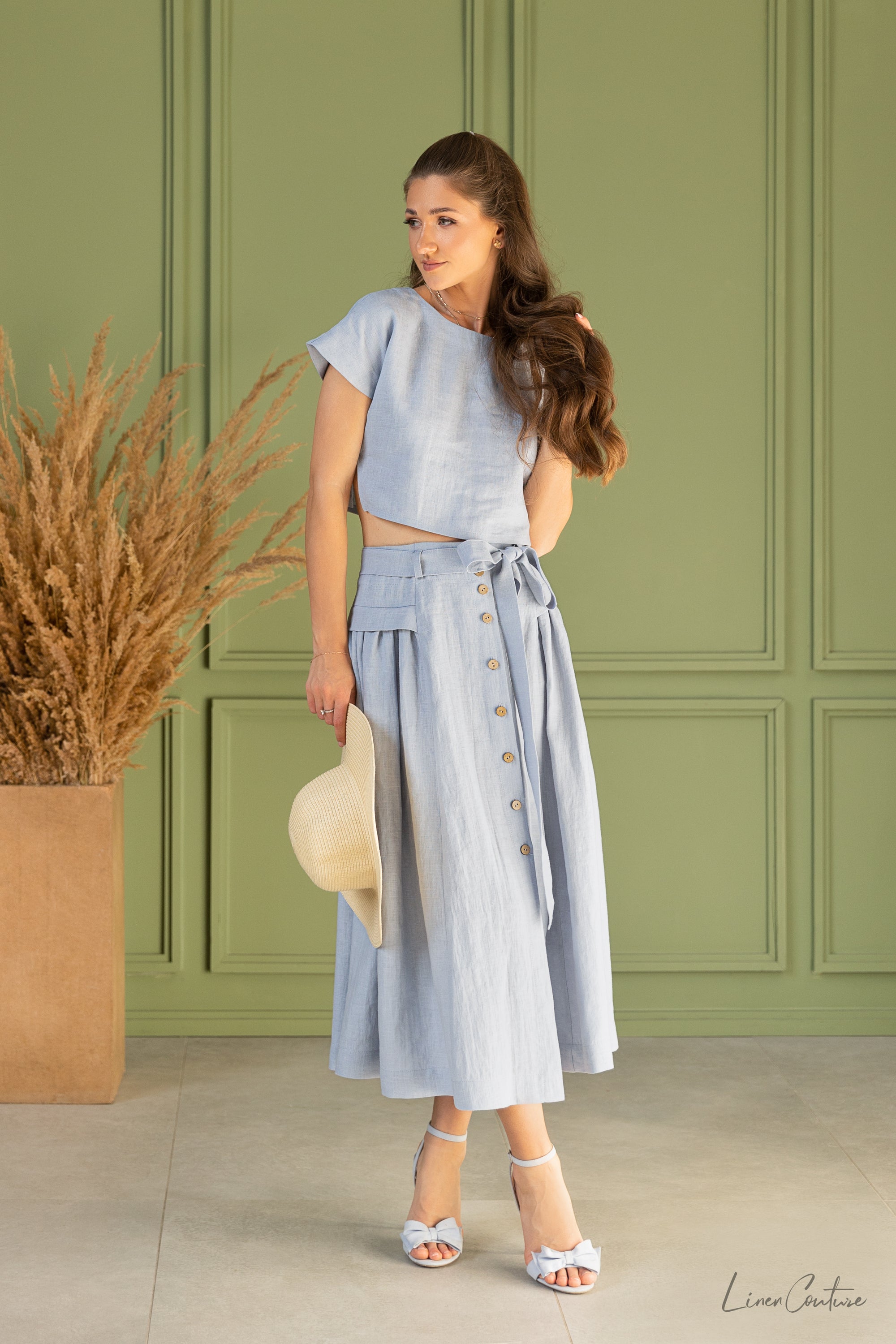 The Taormina Set featuring a linen crop top and flared midi skirt in earthy beige, showcasing its elegant design and breathable fabric.