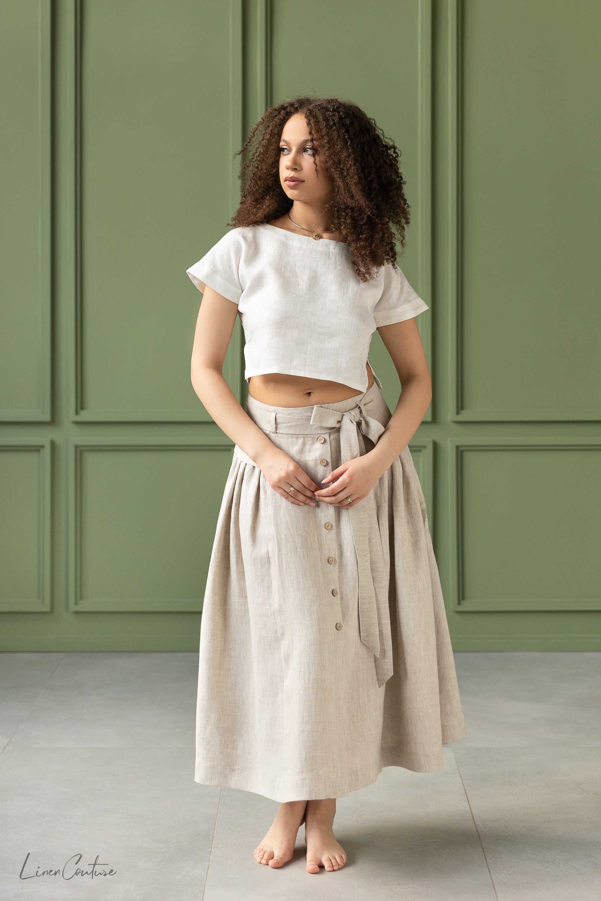 The Taormina Set featuring a linen crop top and flared midi skirt in earthy beige, showcasing its elegant design and breathable fabric.