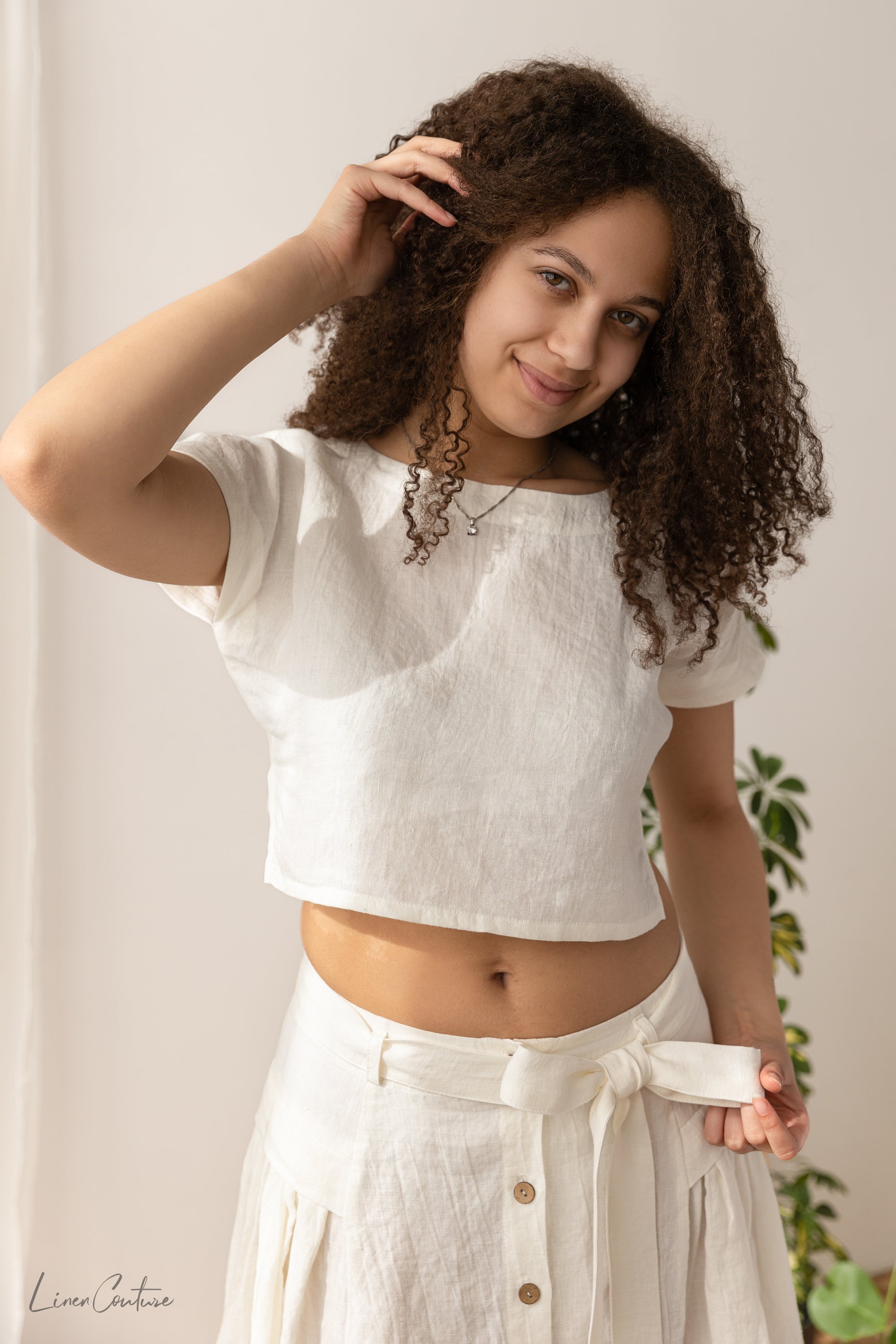 The Taormina Set featuring a linen crop top and flared midi skirt in earthy beige, showcasing its elegant design and breathable fabric.