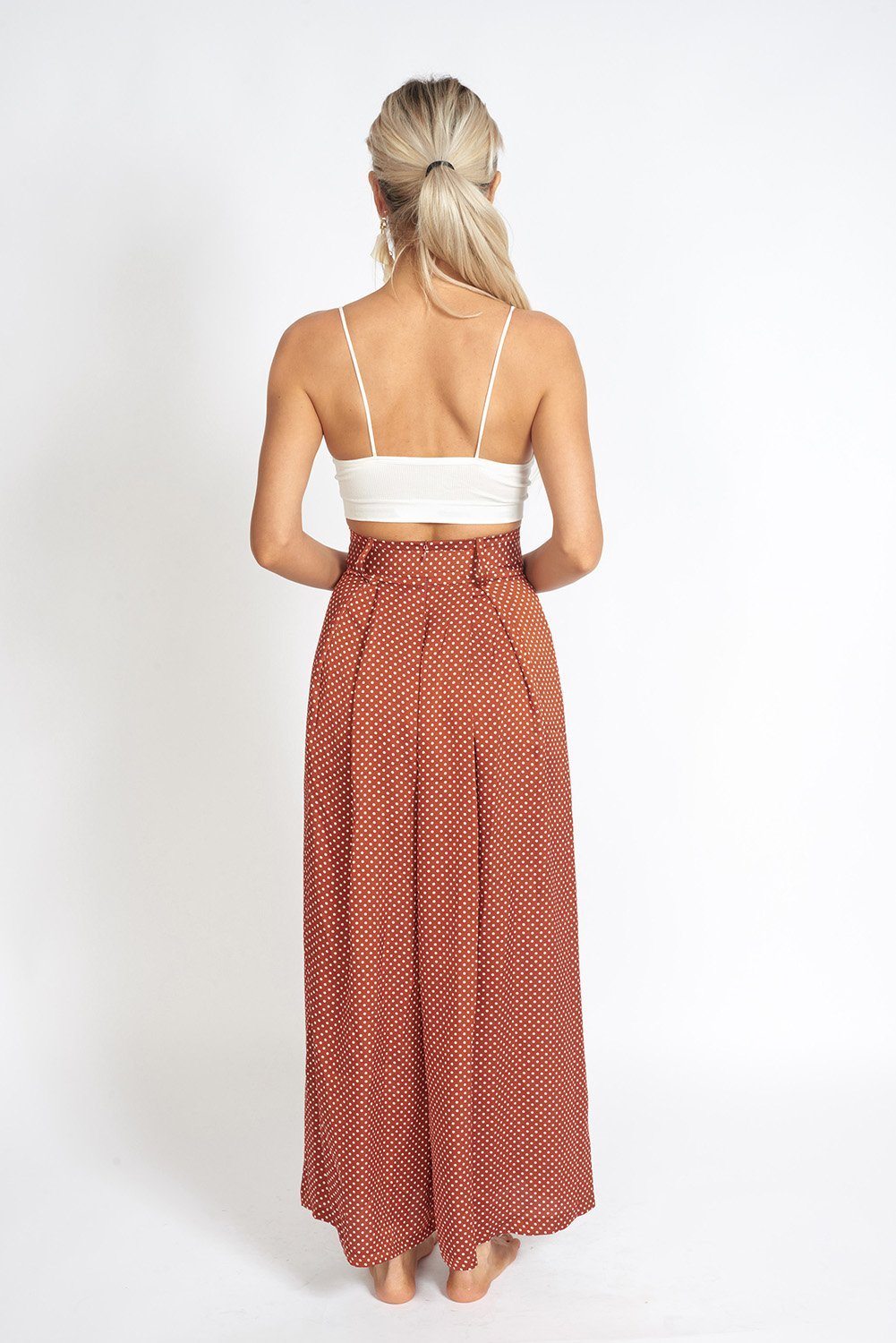 Alessandra Wide Leg Slit Pants featuring a polka-dot print, high-rise waist, and stylish knee slit.