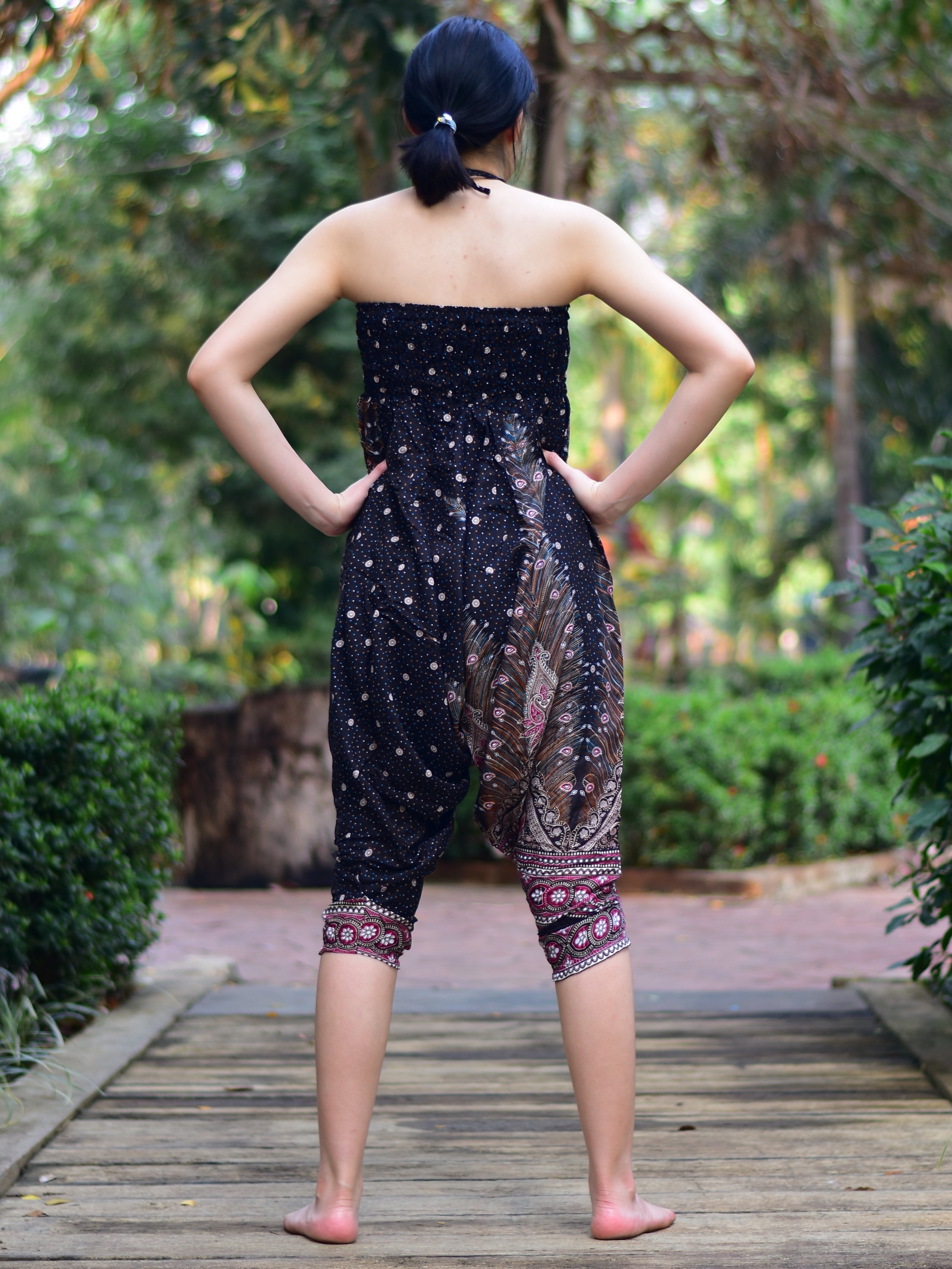 Bohotusk Black Peacock Print Jumpsuit showcasing its elegant design and vibrant colors, perfect for versatile styling.